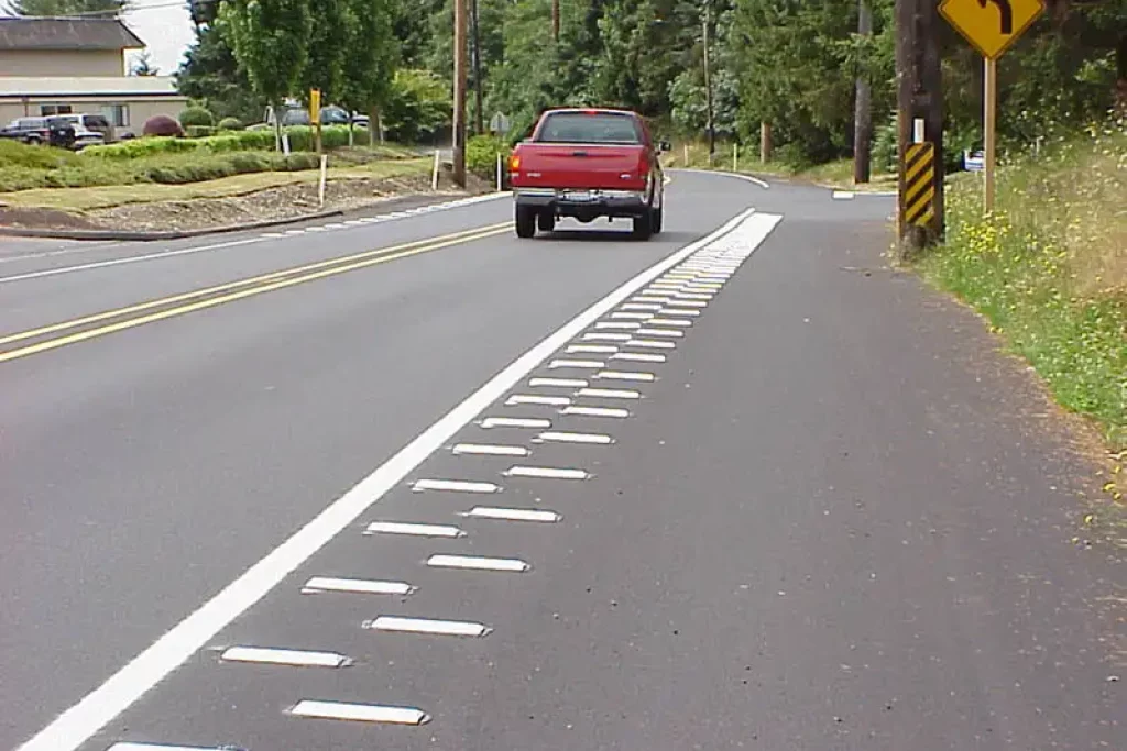 Rumble strips installed on the side of a rural road to alert drivers of lane departure